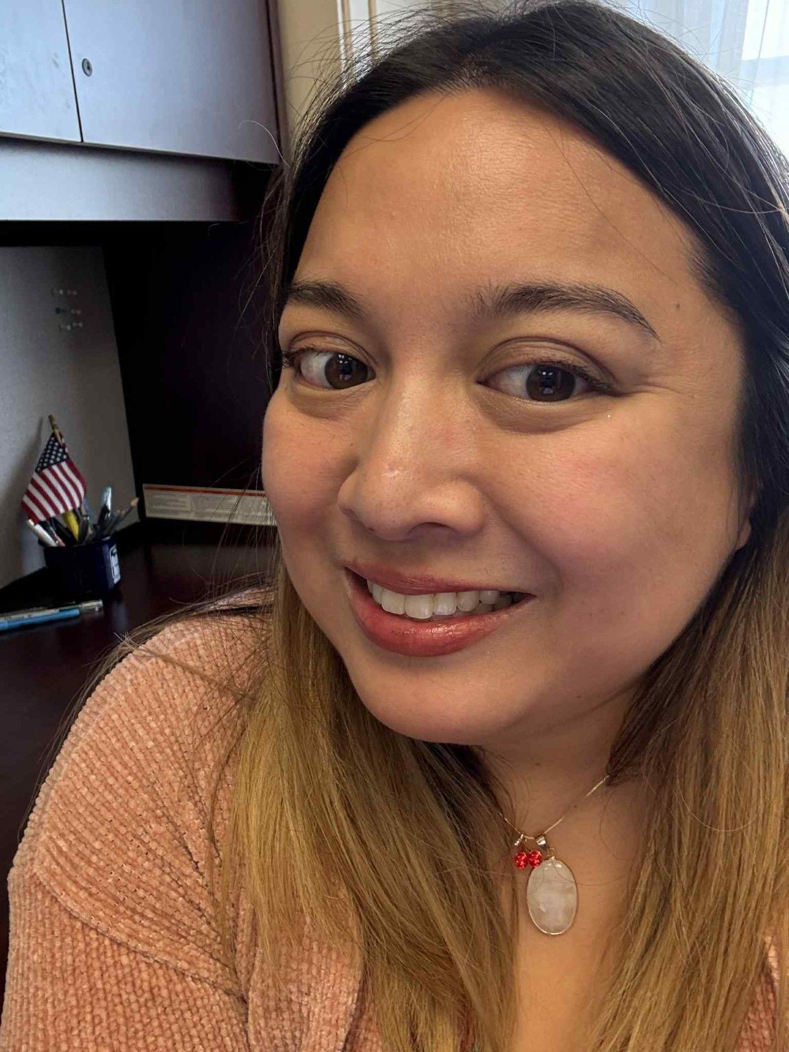 MereBear smiling at her desk